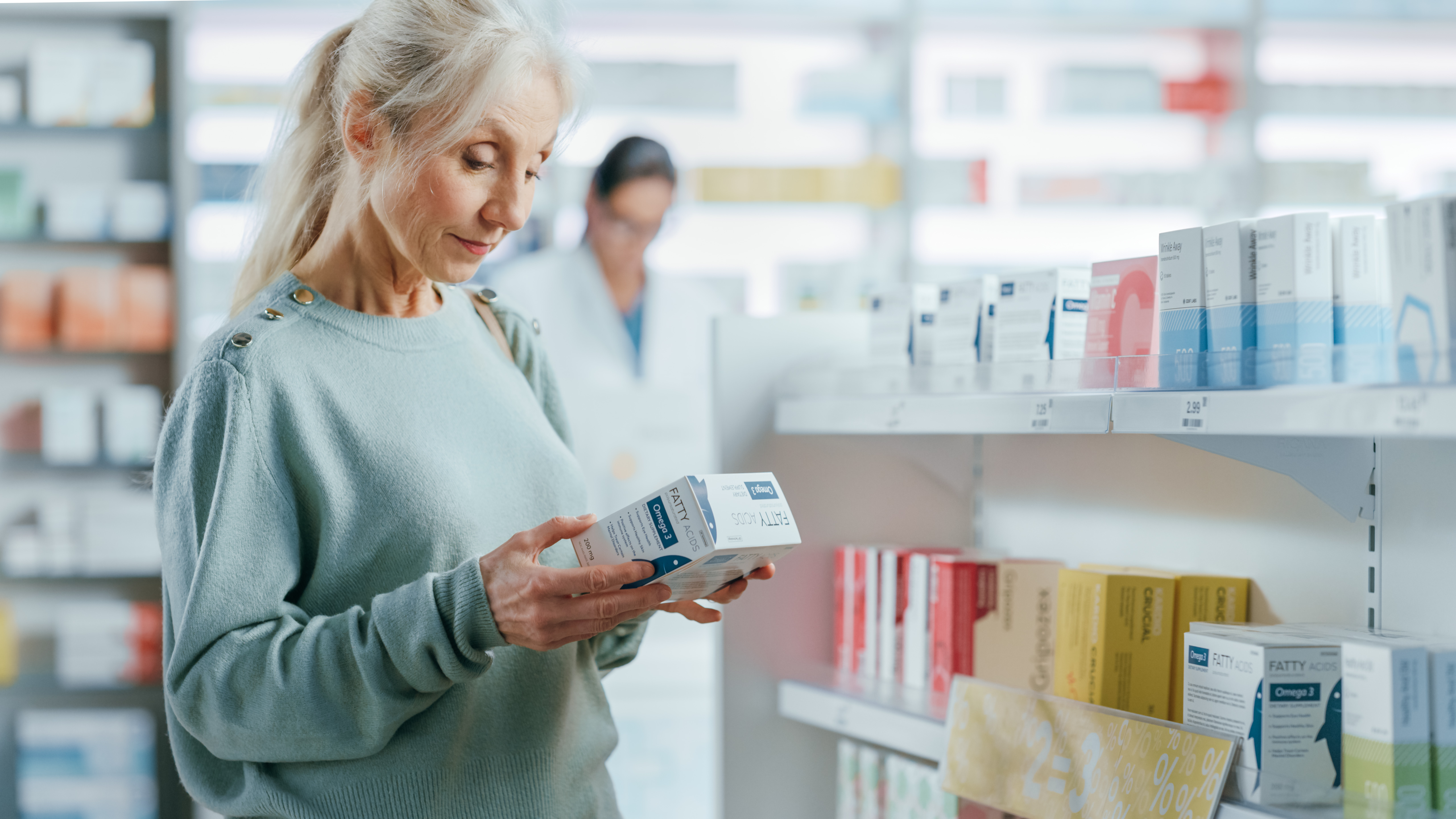Senior woman reading medication label in pharmacy